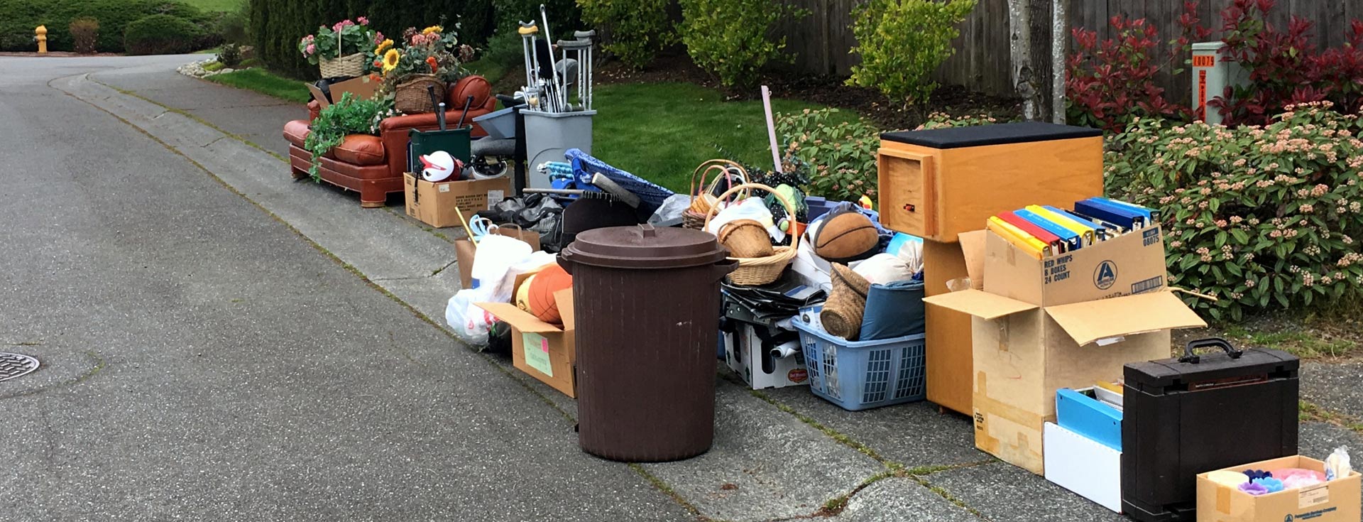 Large pile of assorted household junk and furniture placed on a suburban curbside for junk removal services Kent WA.