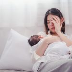 Tired new mother holding her baby, highlighting the need for Postpartum Treatment Chevy Chase for recovery and emotional support.